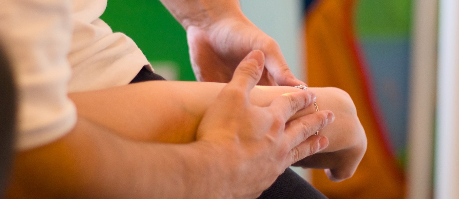 Terapeuta trabajando la muñeca y la mano de un paciente
